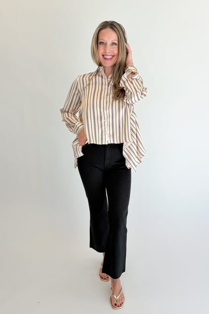 Front view of woman wearing Swagger Boutique’s Ivory &amp; Black Striped Satin Top with jeans against white studio background.