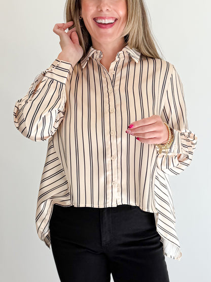 Front detail view of woman wearing Swagger Boutique’s Ivory &amp; Black Striped Satin Top with jeans against white studio background.