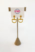 A pair of gold horsebit stud earrings displayed on a burlap-covered stand with a white card labeled Swagger Boutique