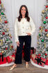 Front view of woman wearing Cream Sherpa Button Up Jacket with jeans around holiday decor.