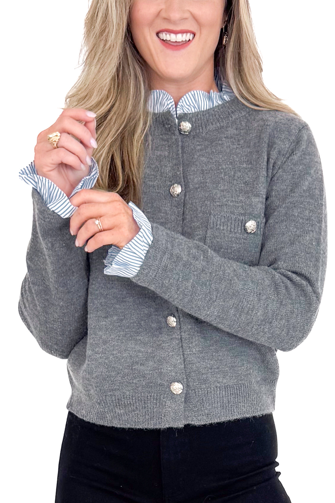 Woman wearing a gray cardigan with a striped shirt underneath on a white background