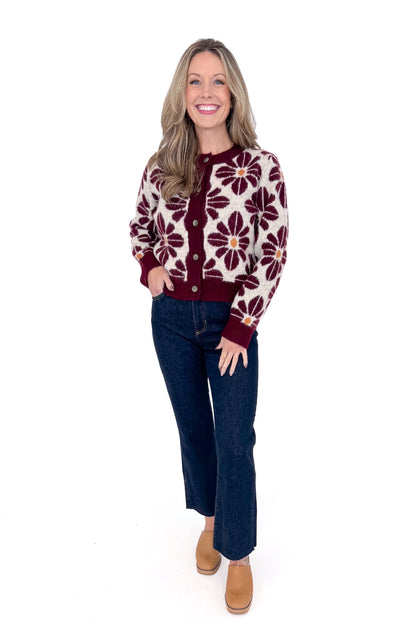 Front view of woman wearing Wine Floral Printed Button Up Cardigan by Entro with jeans against white studio background.