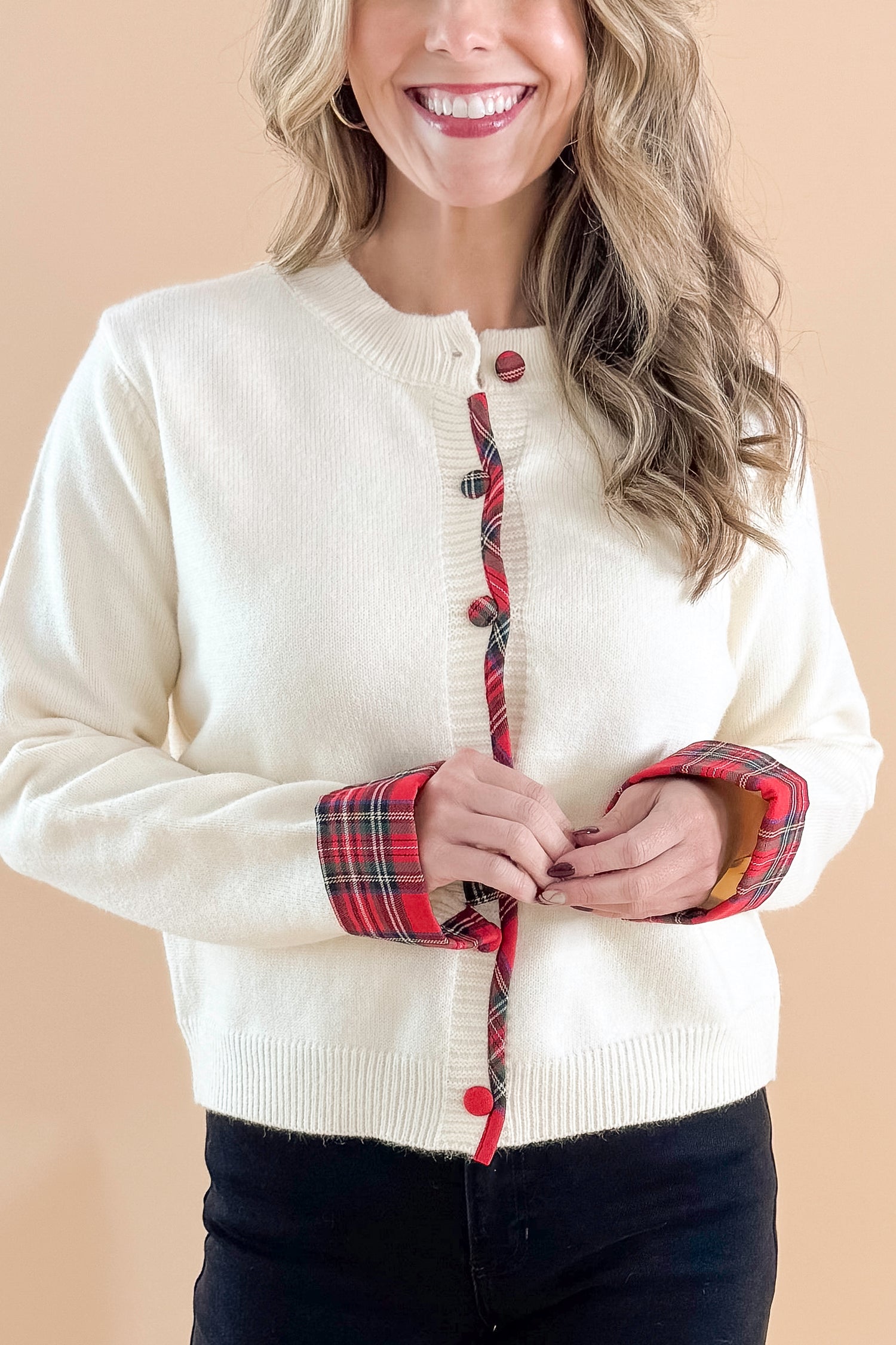 Front detailed view of woman wearing Cream With Tartan Detail Button Up Cardigan with jeans against tan studio background.