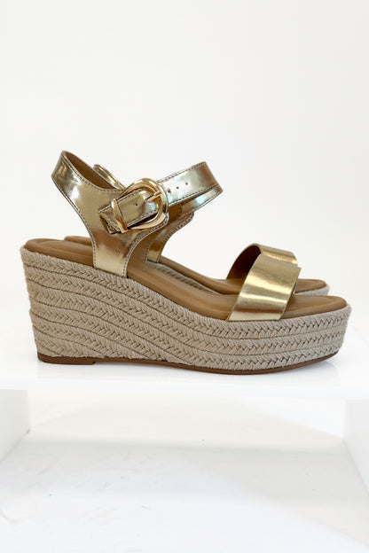 Side view Jena Gold and Rattan Wedge shoes against white studio background.