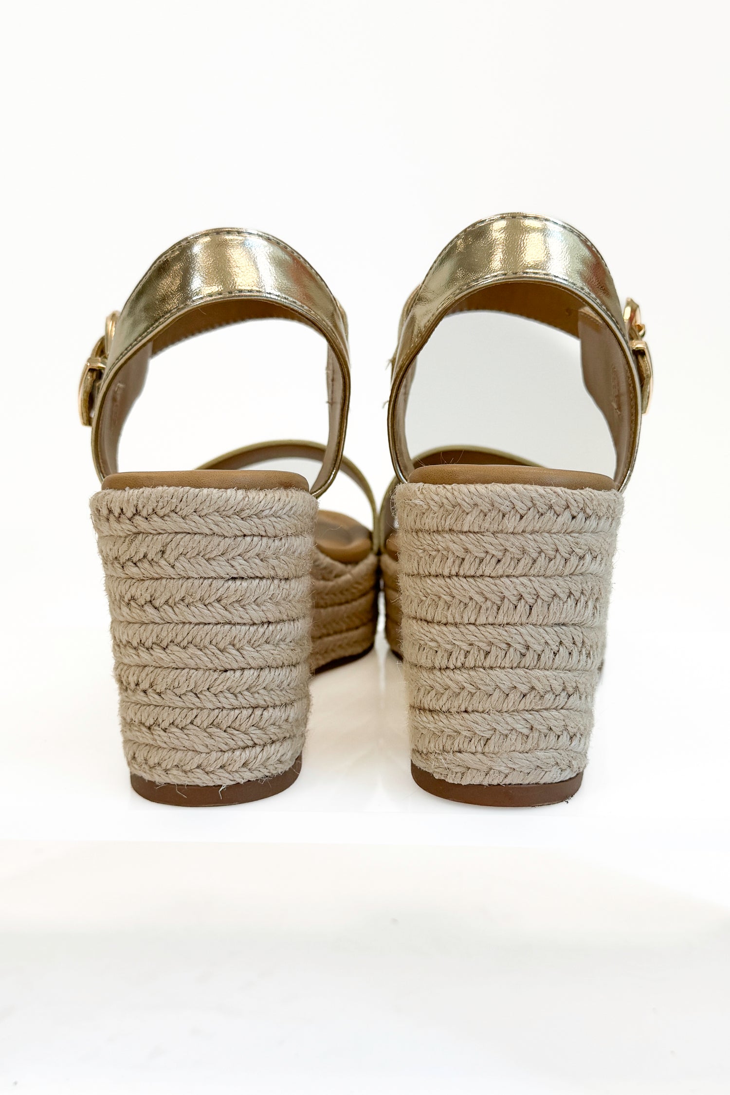 Jena Gold and Rattan Wedge shoes against white studio background back view.
