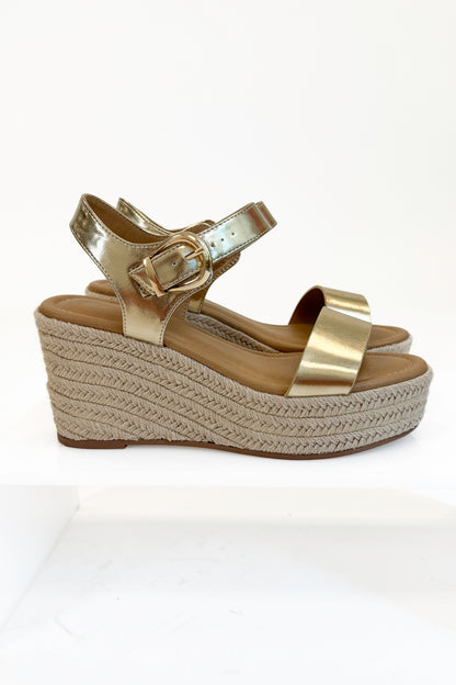 Jena Gold and Rattan Wedge shoes against white studio background side view.