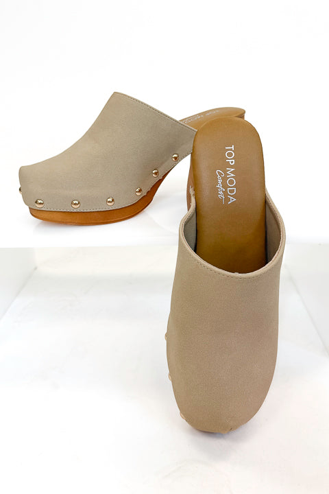 Jungle- Beige Studded Clogs against studio background