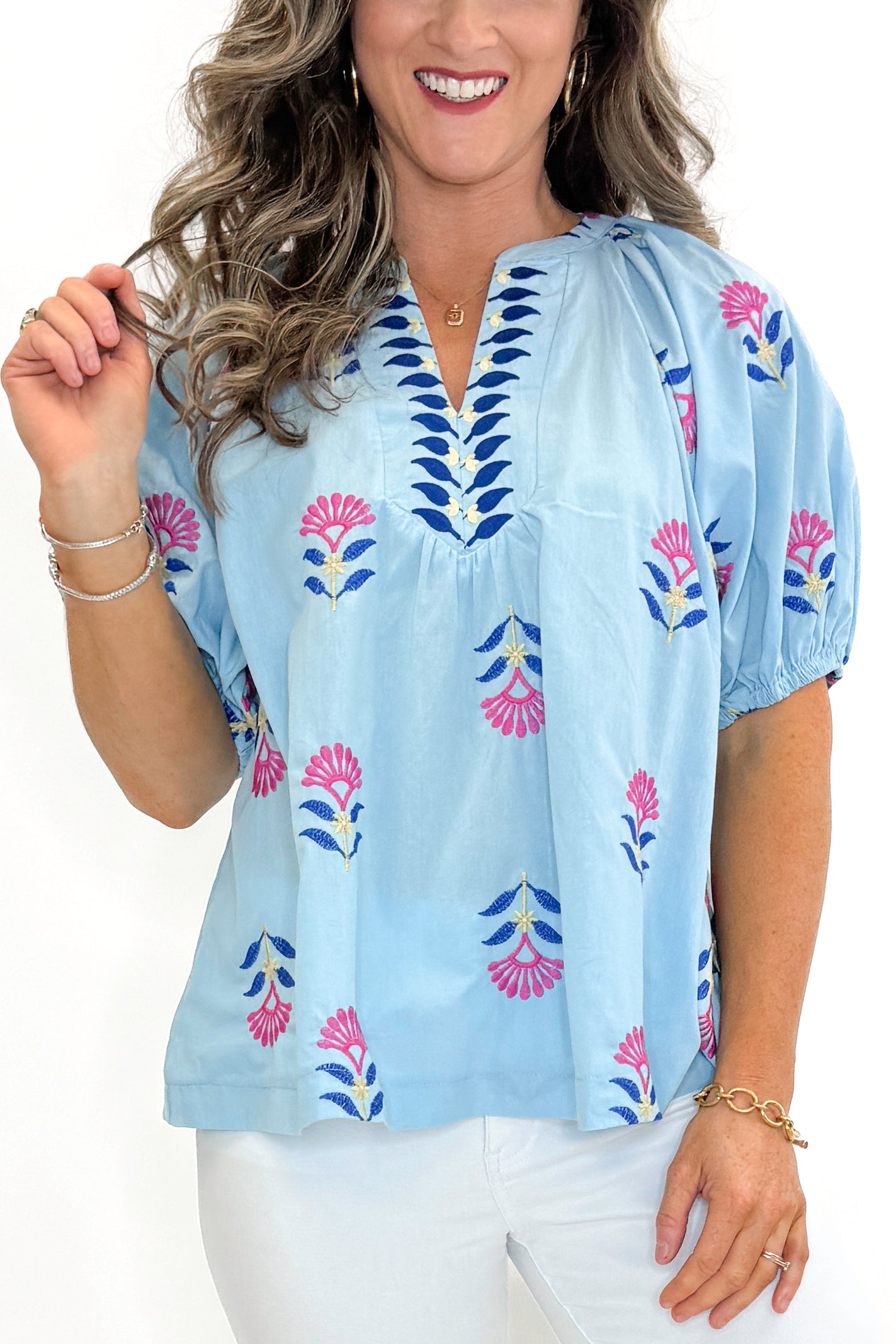 Front detail view of woman wearing Blue &amp; Multi Floral Embroidered Top with jeans against white studio background.