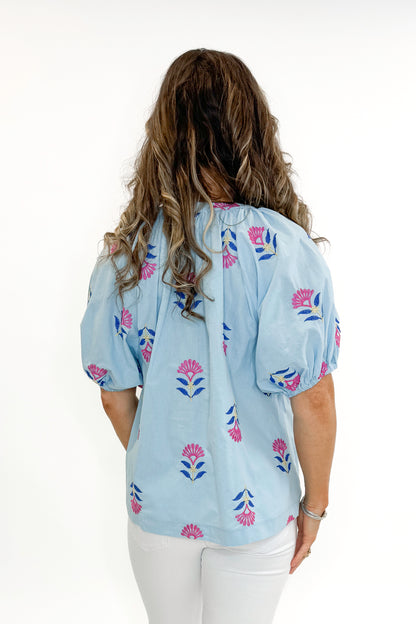Backl view of woman wearing Blue &amp; Multi Floral Embroidered Top with jeans against white studio background.
