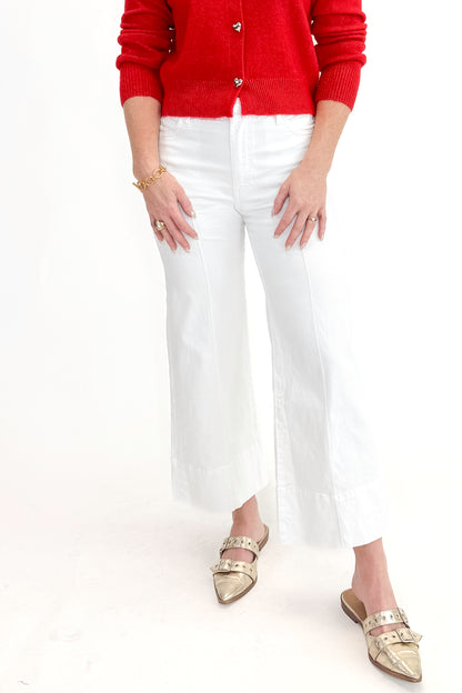 Front view of woman wearing top with Meg Optic White Pintuck Wide Leg Jeans by Kut from the Kloth against white studio background. 