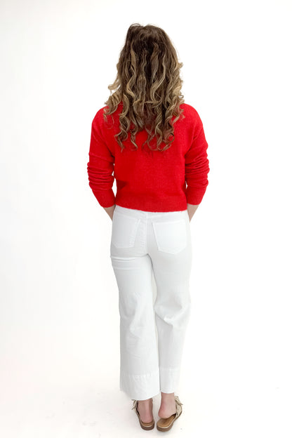 Back view of woman wearing top with Meg Optic White Pintuck Wide Leg Jeans by Kut from the Kloth against white studio background. 