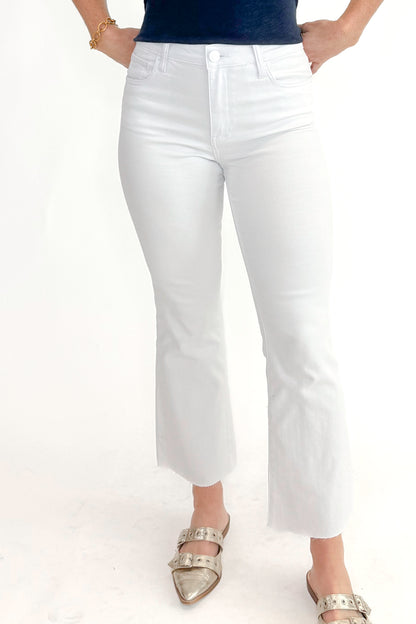 Front view of woman wearing top with Kelsey Optic White Ankle Flare Jeans by Kut from the Kloth against white studio background.