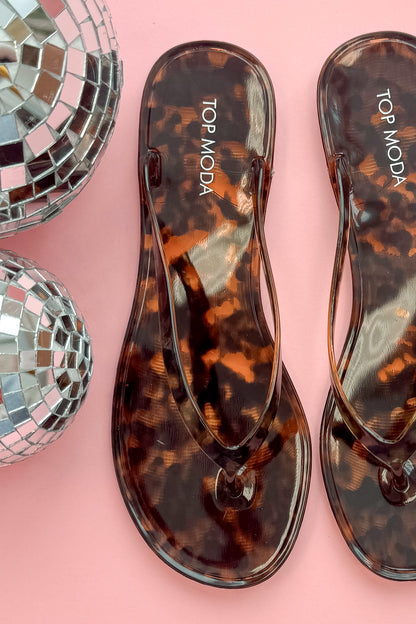 Kate- Tortoise Flip Flops close up against a pink background