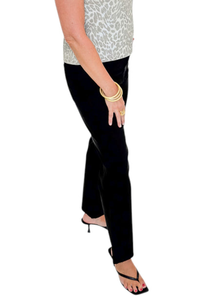 Side view of woman wearing Swagger Boutique’s Kelsey Ankle Flare Jeans In Black by Kut from the Kloth with top against white studio background.