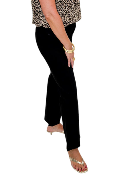 Side view of woman wearing Swagger Boutique’s Kelsey Ankle Flare Jeans In Black by Kut from the Kloth with top against white studio background.