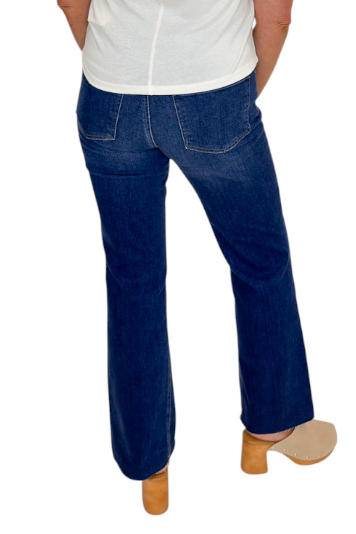 Back view of woman wearing Swagger Boutique’s Kelsey Ankle Flare Jeans In Dark Wash- Improve by Kut from the Kloth with top against white studio background.