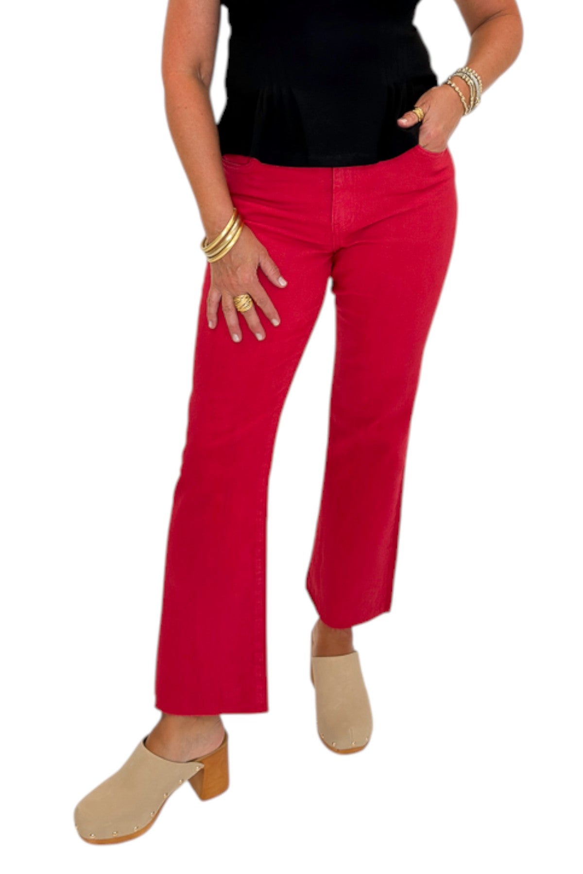 Front view of woman wearing Swagger Boutique’s Kelsey Ankle Flare Jeans In Ruby Red by Kut from the Kloth with black top against white studio background.