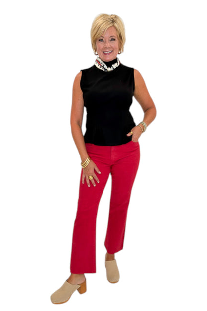 Front view of woman wearing Swagger Boutique’s Kelsey Ankle Flare Jeans In Ruby Red by Kut from the Kloth with black top against white studio background.