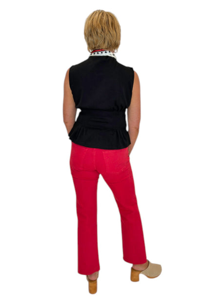 Back view of woman wearing Swagger Boutique’s Kelsey Ankle Flare Jeans In Ruby Red by Kut from the Kloth with black top against white studio background.