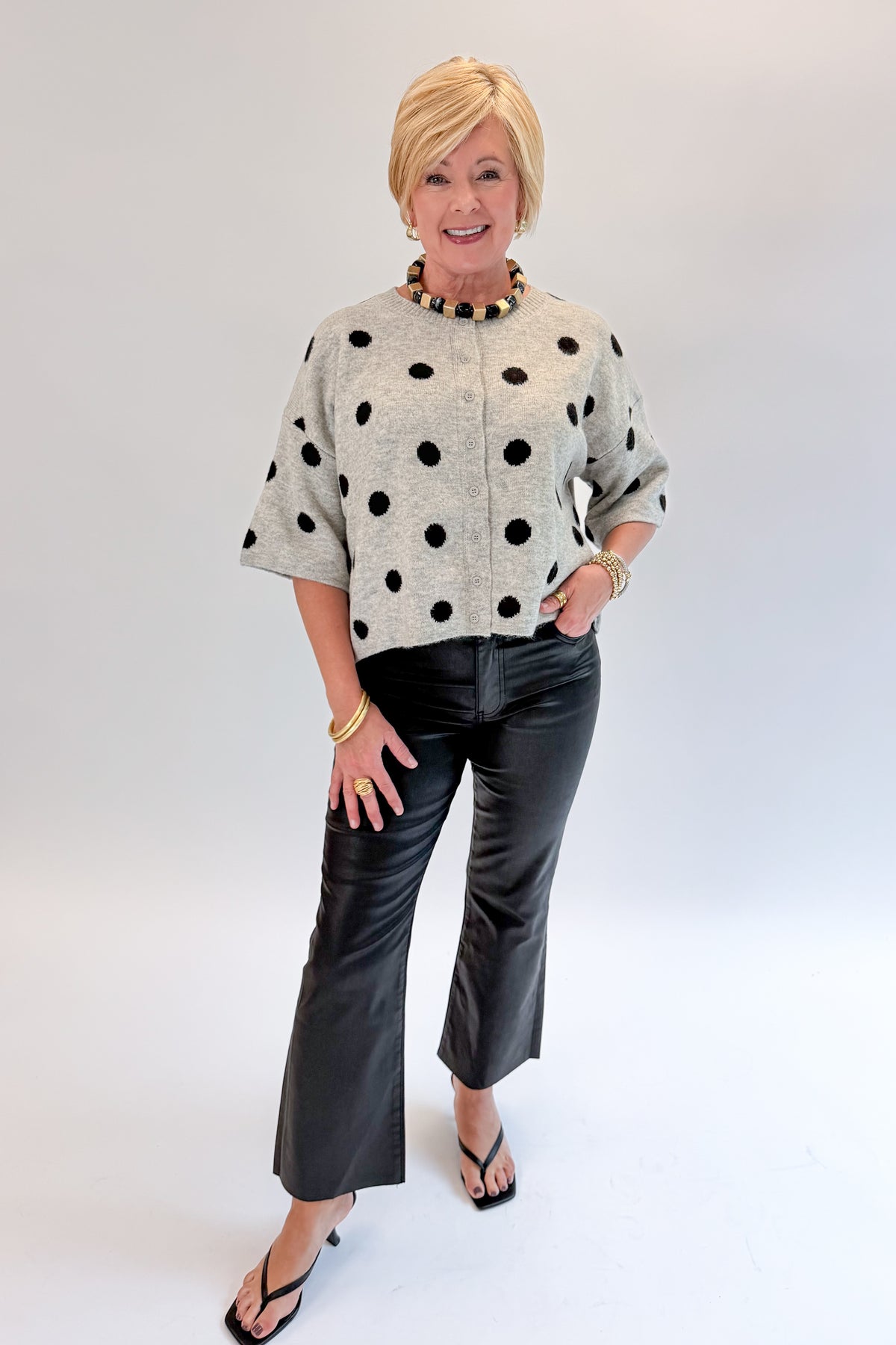 Front view of woman wearing Swagger Boutique’s Kelsey Coated Ankle Flare Jeans in Black by Kut from the Kloth against white studio background.