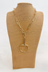 Gold necklace with a large horsebit pendant on a brown mannequin bust against a white background