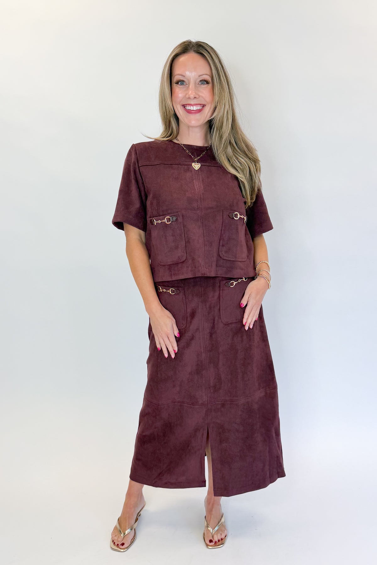 Front view of woman wearing Swagger Boutique’s Merlot Suede Horsebit Pocket Top &amp; Skirt by Entro against white studio background.