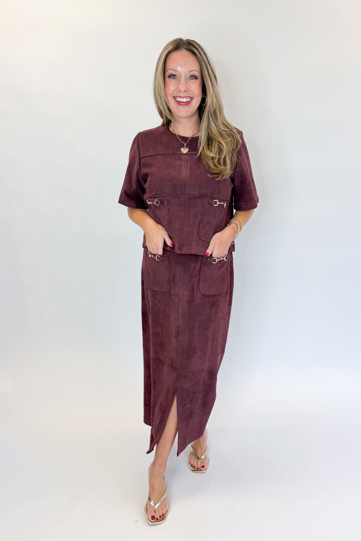 Front view of woman wearing Swagger Boutique’s Merlot Suede Horsebit Pocket Top &amp; Skirt by Entro against white studio background.