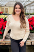 Front view of woman wearing Cream With Gold Sequin Sweater with jeans by holiday decor.