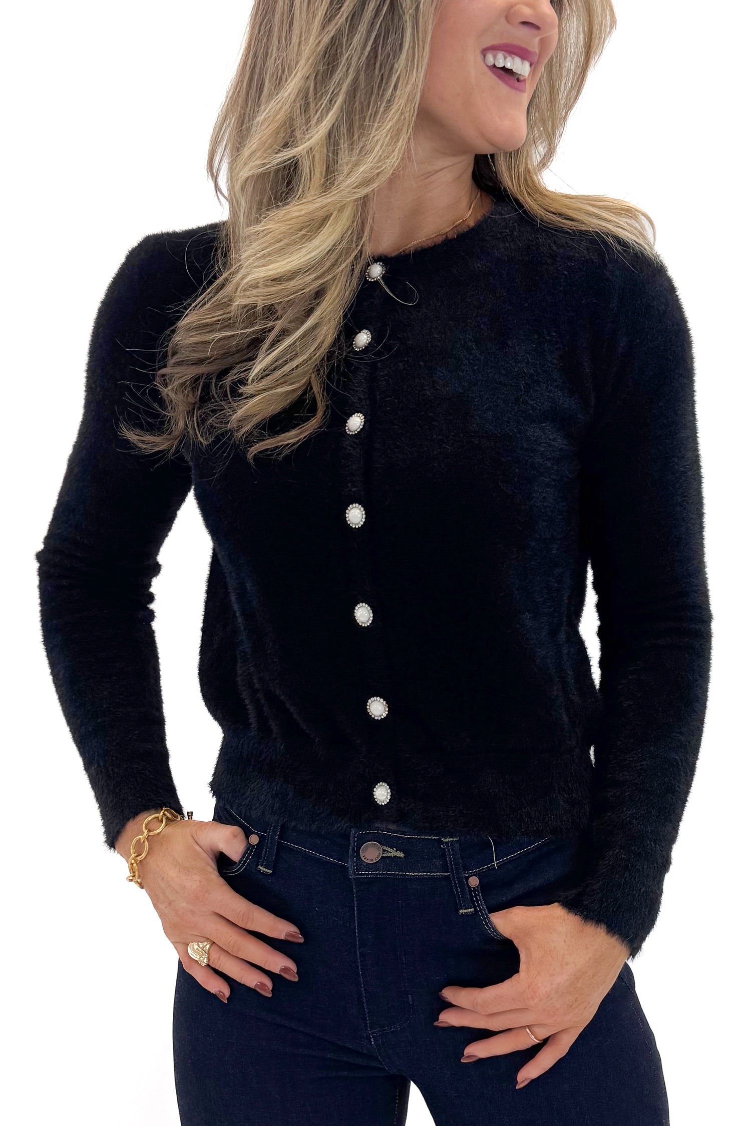 Front detail view of woman wearing Black With Rhinestone Buttons Eyelash Cardigan with jeans against white studio background. 