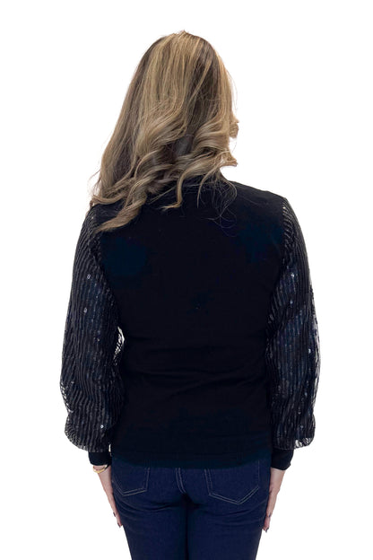 Back view of woman wearing Black Sequined Sleeve Turtleneck Sweater with jeans against white studio background.