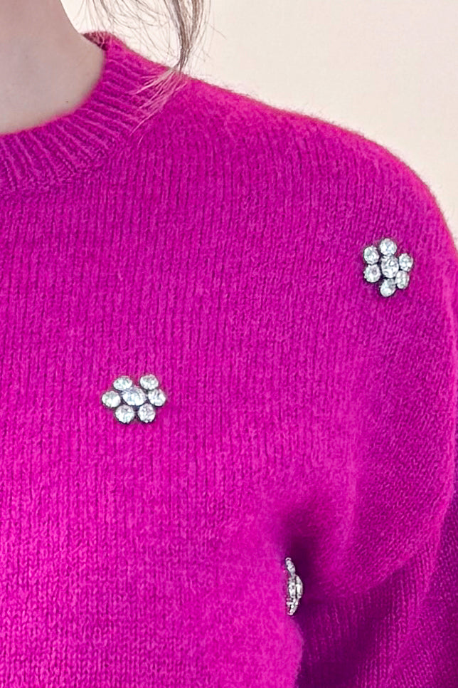 Detailed view of woman wearing Magenta Rhinestone Detail Sweater against tan studio background.