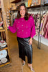 Front view of woman wearing Magenta Rhinestone Detail Sweater with black skirt against boutique background.