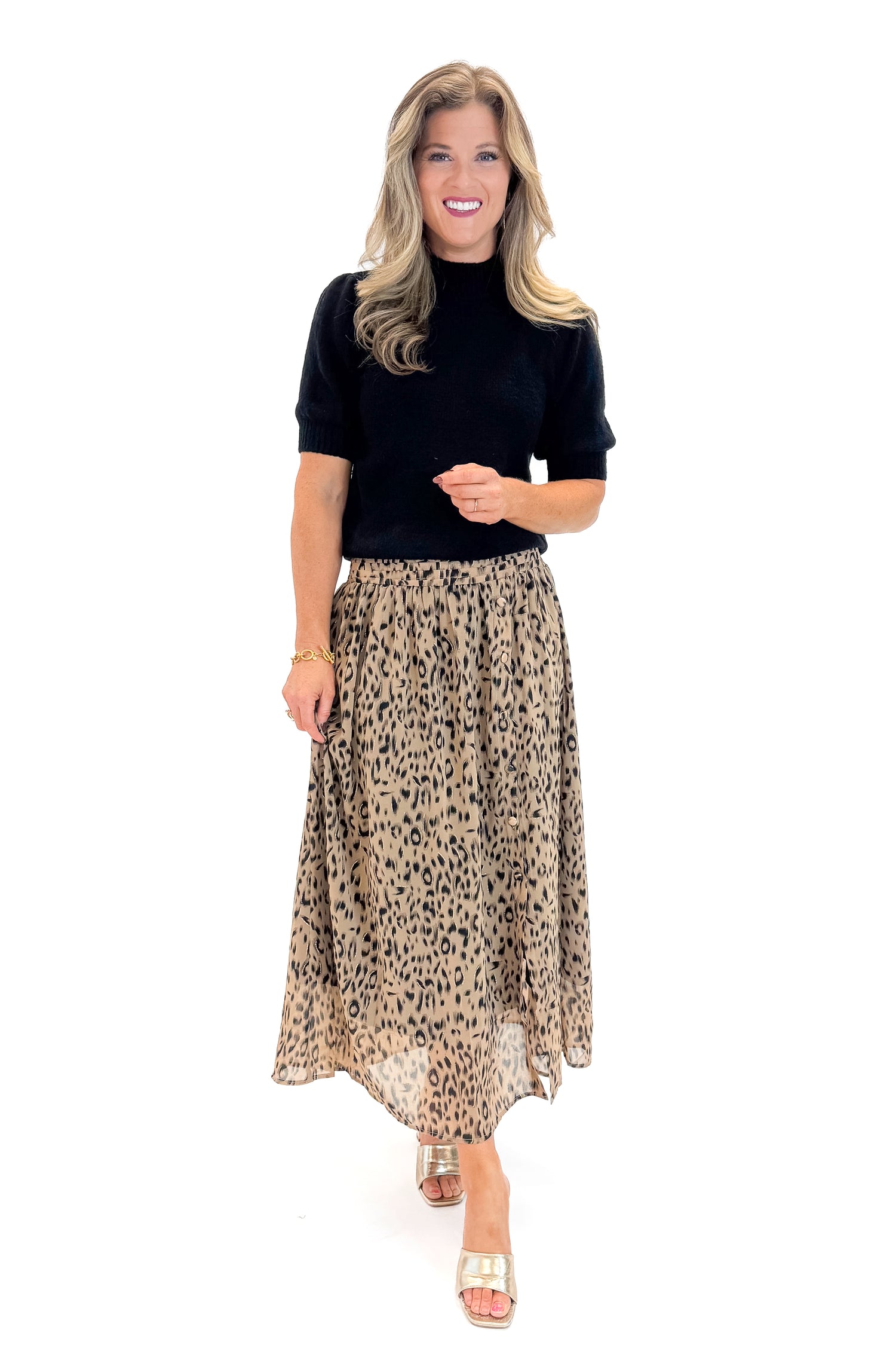 Front view of woman wearing black sweater with Beige Leopard Button Detail Skirt against white studio background.