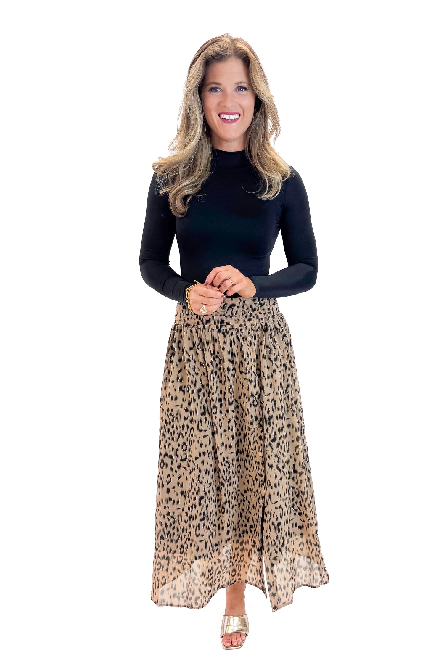 Front view of woman wearing black top with Beige Leopard Button Detail Skirt against white studio background.