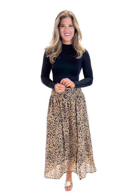 Front view of woman wearing black top with Beige Leopard Button Detail Skirt against white studio background.