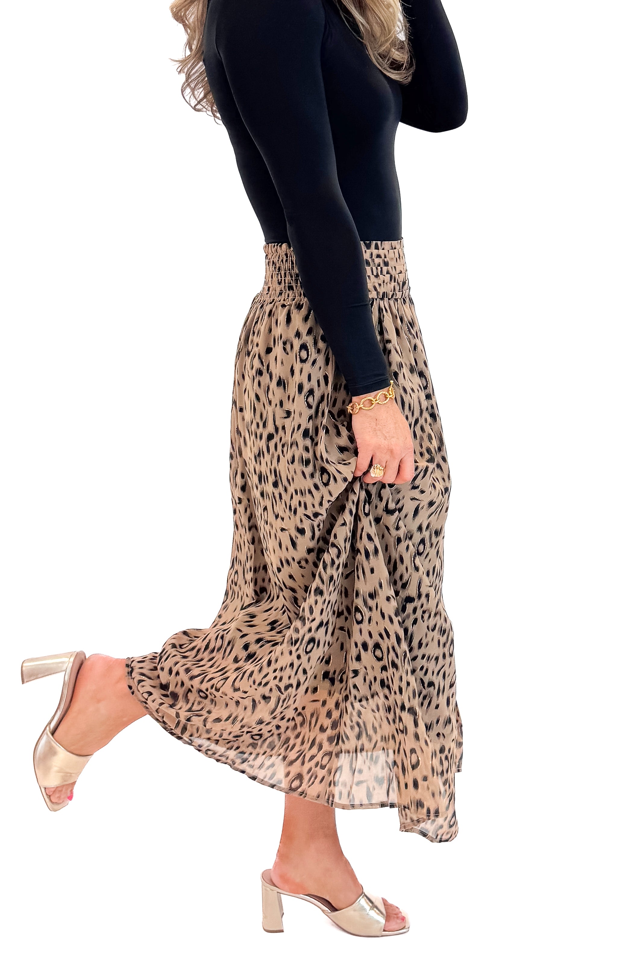 Side view of woman wearing black top with Beige Leopard Button Detail Skirt against white studio background.
