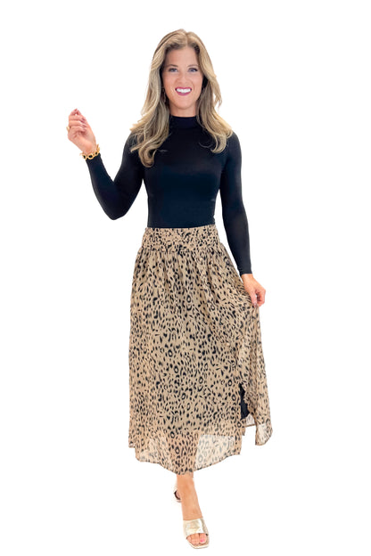 Front view of woman wearing black top with Beige Leopard Button Detail Skirt against white studio background.