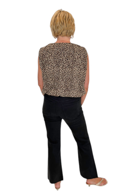 Back view of woman wearing Swagger Boutique’s Leopard Bubble Hem Top with jeans against white studio background.
