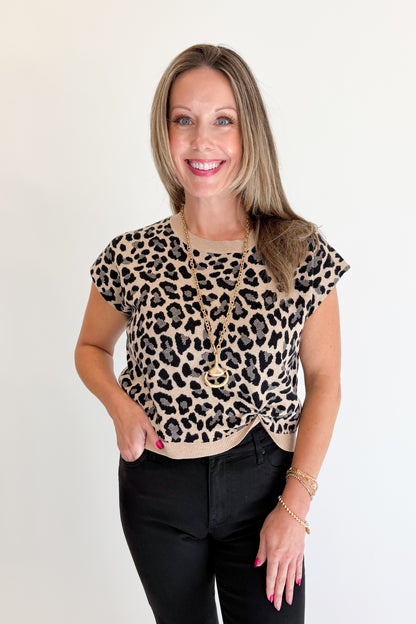 Front view of woman wearing Swagger Boutique’s Leopard Knotted Short Sleeve Sweater with jeans against white studio background.