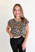 Front view of woman wearing Swagger Boutique’s Leopard Knotted Short Sleeve Sweater with jeans against white studio background.