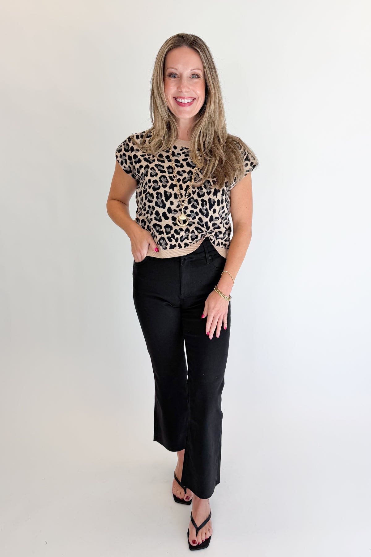 Front view of woman wearing Swagger Boutique’s Leopard Knotted Short Sleeve Sweater with jeans against white studio background.