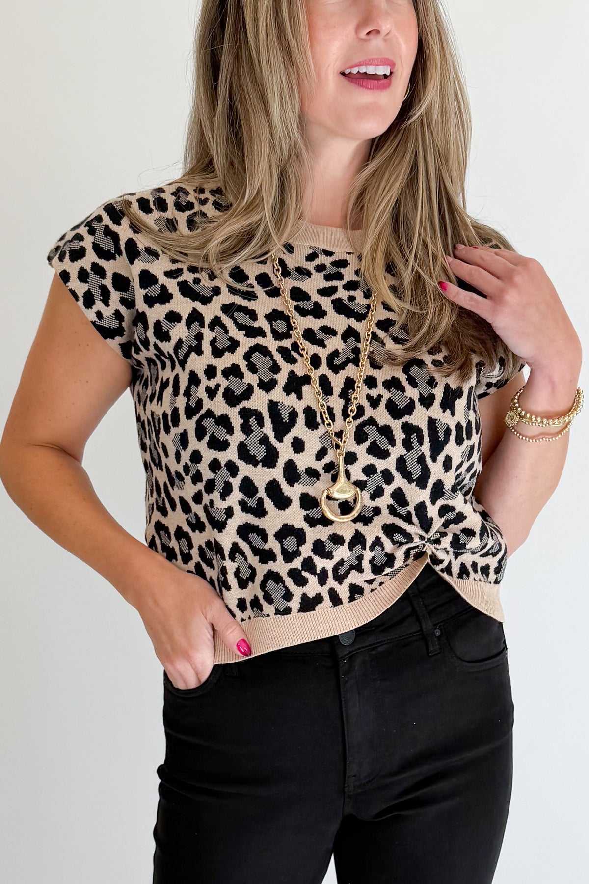 Front detail view of woman wearing Swagger Boutique’s Leopard Knotted Short Sleeve Sweater with jeans against white studio background.