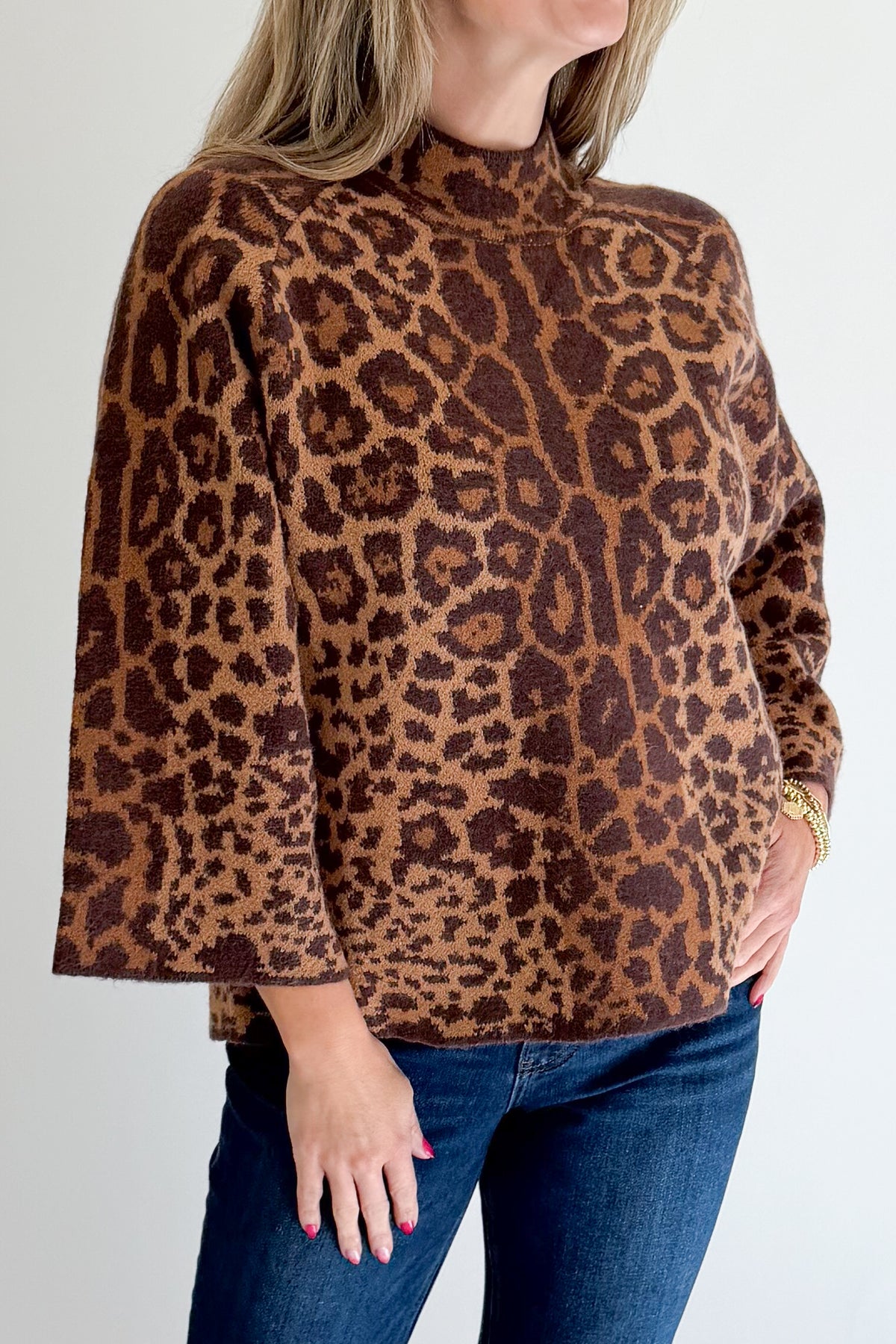 Front detail view of woman wearing Swagger Boutique’s Leopard Print Mock Neck Sweater by Entro with jeans against white studio background.