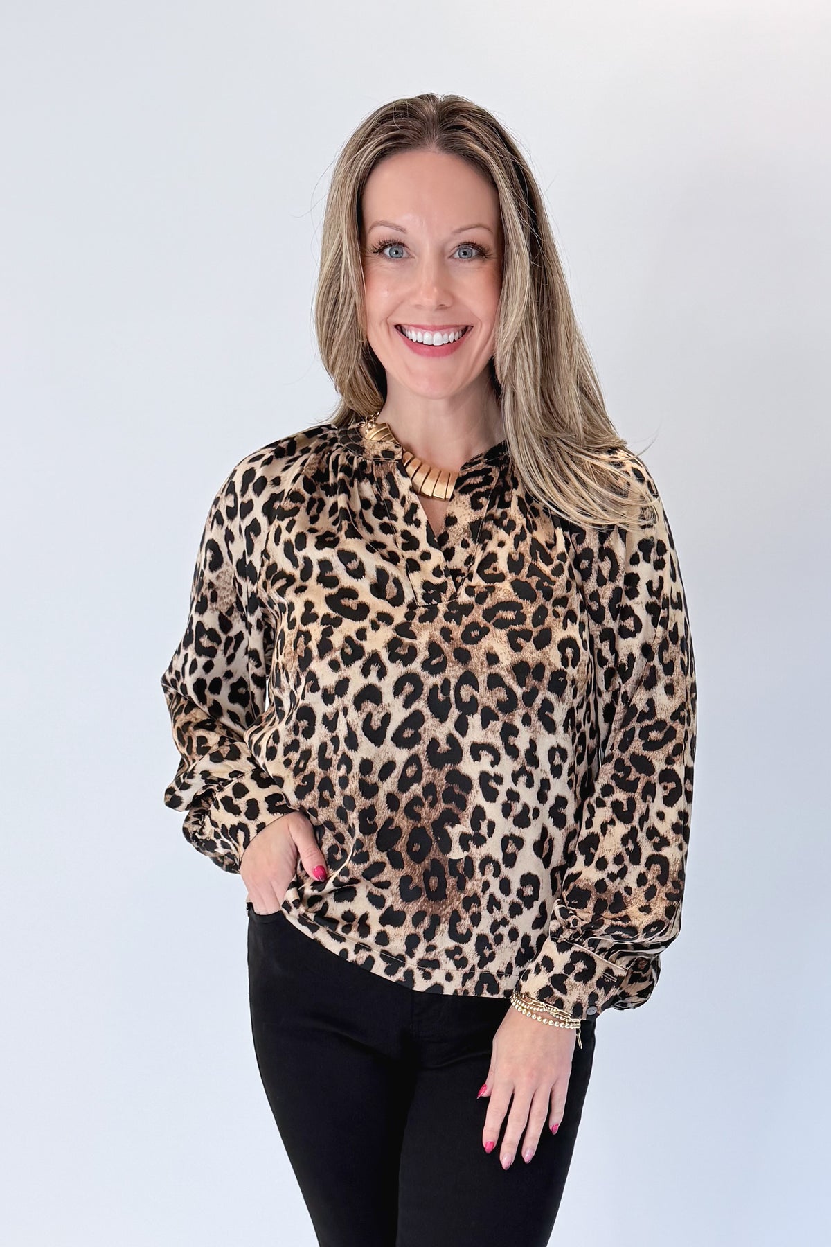 Front view of woman wearing Swagger Boutique’s Leopard Print Silky Top with jeans against white studio background.