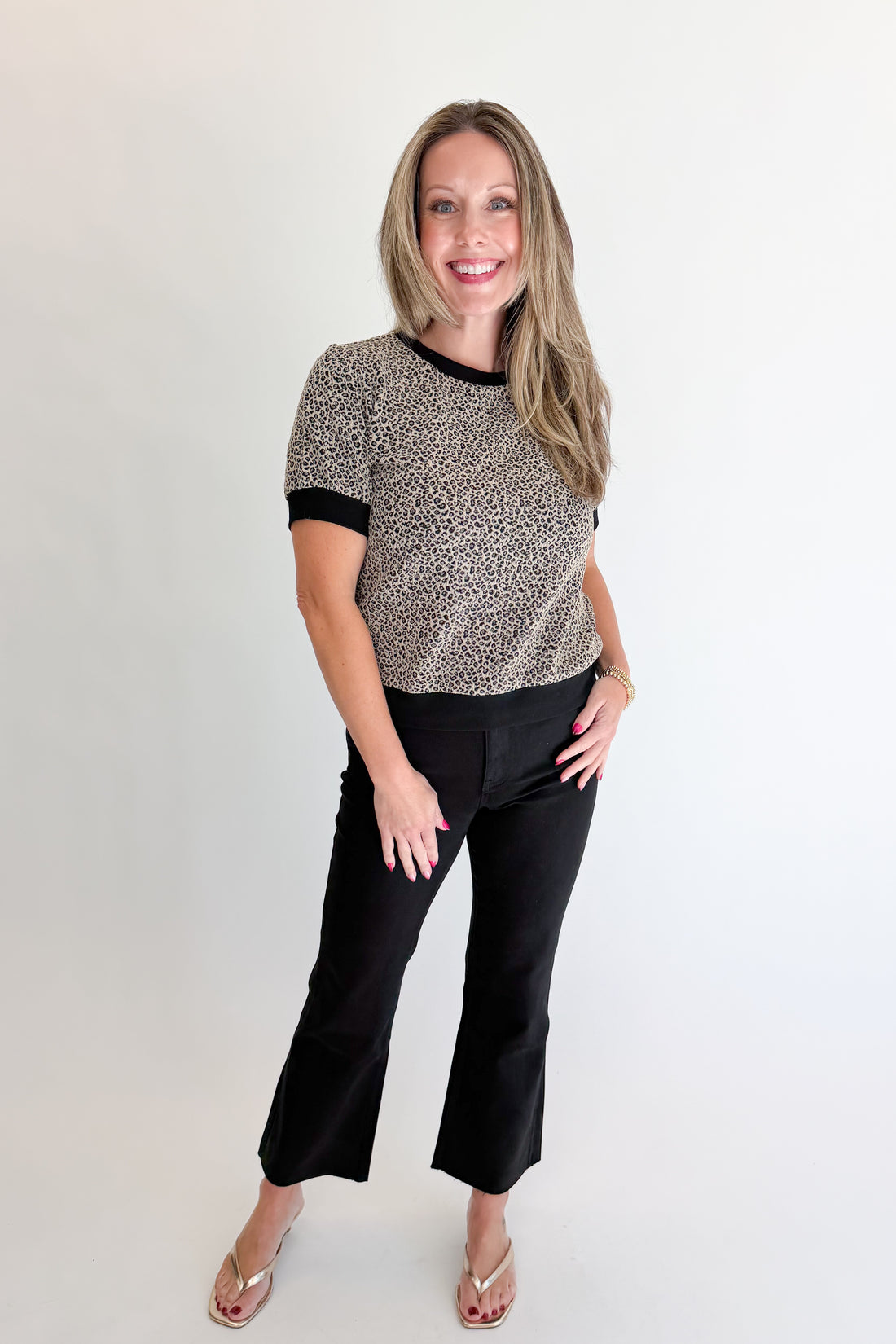Front view of woman wearing Swagger Boutique’s Leopard Textured Short Sleeve Top with jeans against white studio background.