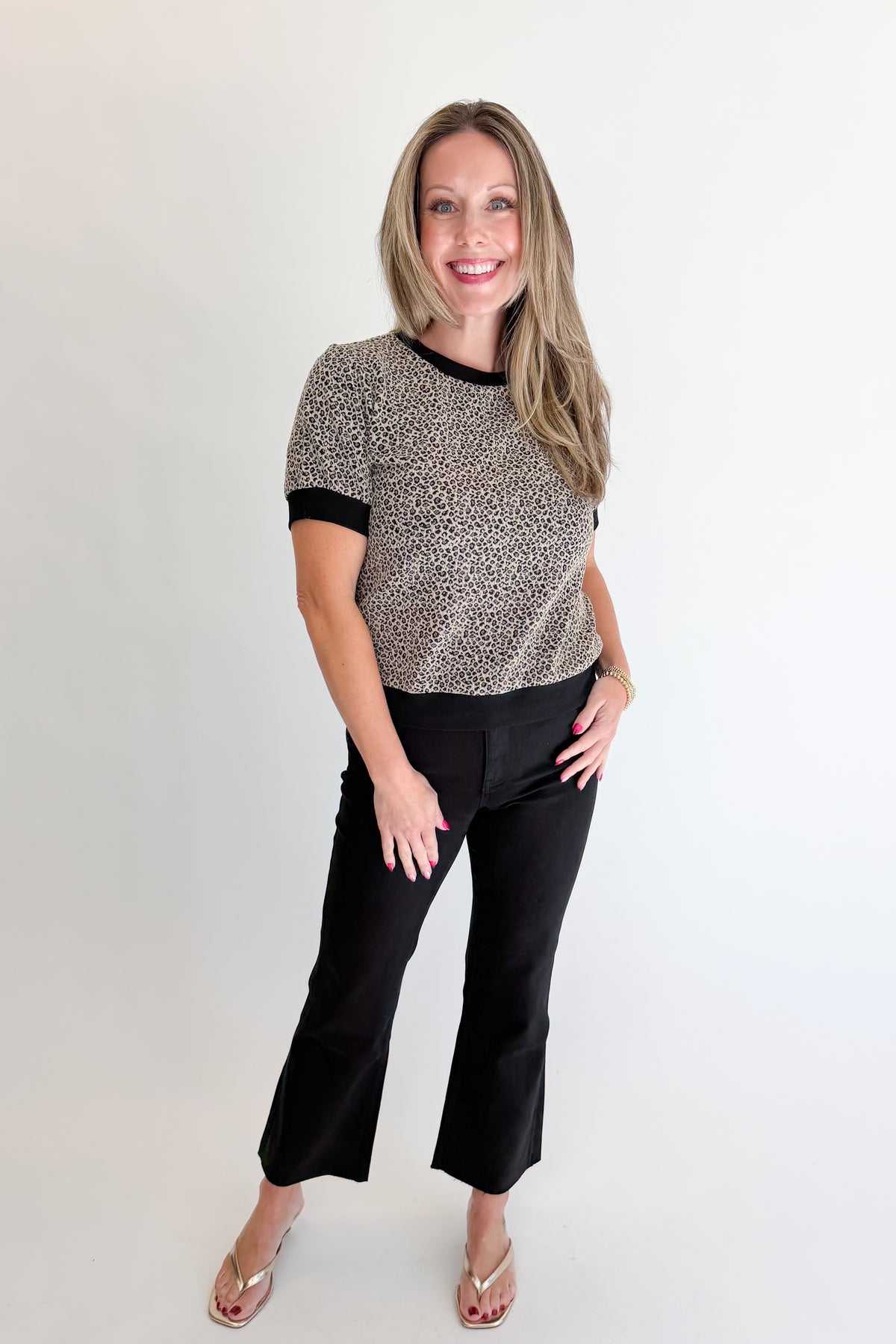 Front view of woman wearing Swagger Boutique’s Leopard Textured Short Sleeve Top with jeans against white studio background.