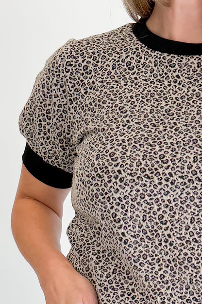 Front detail view of woman wearing Swagger Boutique’s Leopard Textured Short Sleeve Top with jeans against white studio background.