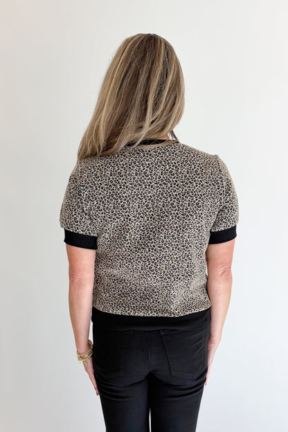 Back view of woman wearing Swagger Boutique’s Leopard Textured Short Sleeve Top with jeans against white studio background.