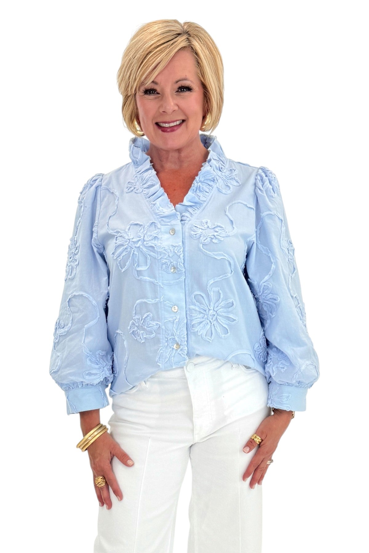 Front view of woman wearing Swagger Boutique’s Light Blue Floral 3/4 Sleeve Embroidered Top with jeans against white studio background.