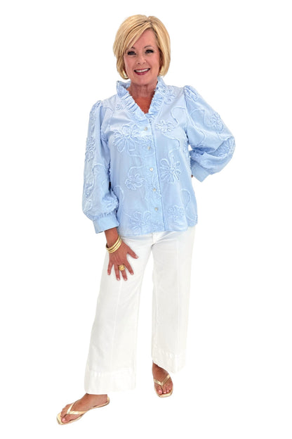 Front view of woman wearing Swagger Boutique’s Light Blue Floral 3/4 Sleeve Embroidered Top with jeans against white studio background.